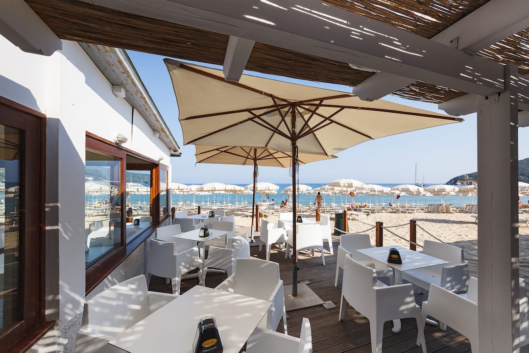 Una famiglia monta i gonfiabili sulla spiaggia attrezzata, pronta a godersi una giornata di divertimento al mare.