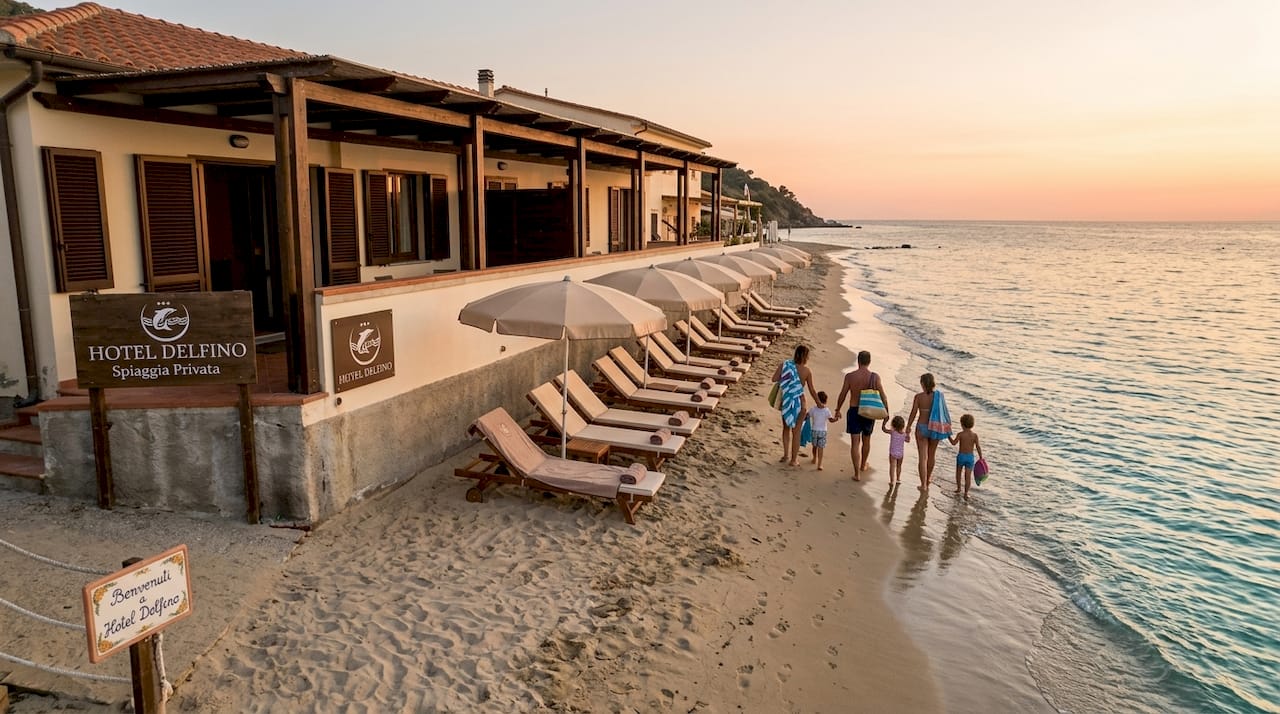 Hotel sul mare all’Isola d’Elba, con una famiglia che passeggia sulla spiaggia.