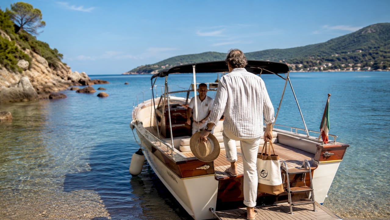 Un uomo si lancia su un taxi boat al porto di Elba