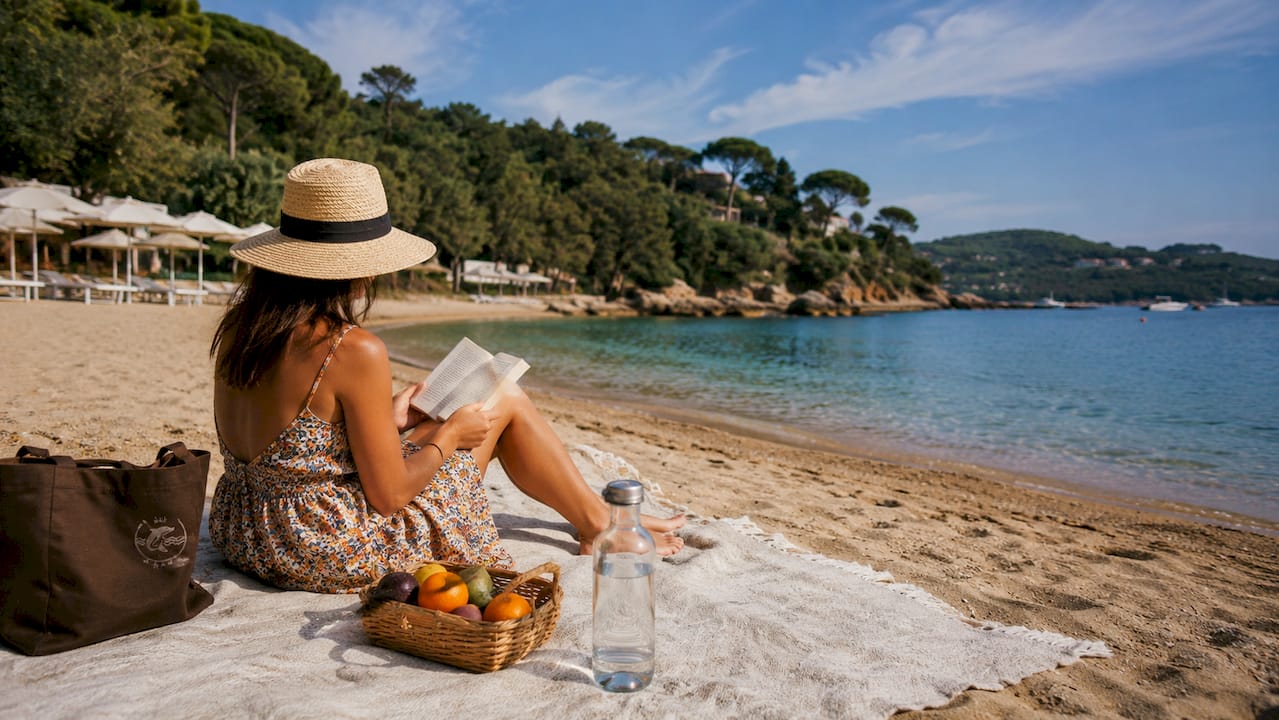Donna che si gode un momento di relax su una sdraio in spiaggia all’Isola d’Elba